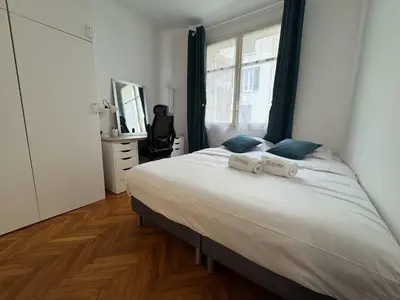 a bedroom with a large white bed with blue pillows at C070 Magnifique appartement au calme 2 Chambre centre in Cannes