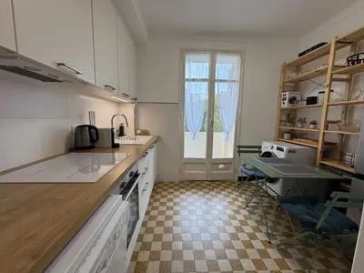 a kitchen with white cabinets and a checkered floor at C070 Magnifique appartement au calme 2 Chambre centre in Cannes