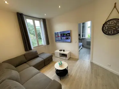 a living room with a couch and a table at 2 pièces au calme in Cannes