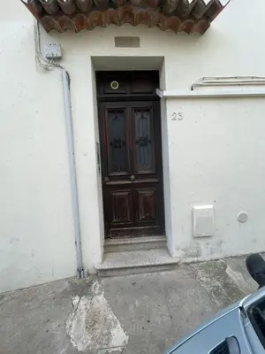 a door of a white house with aphalt at 2 pièces au calme in Cannes