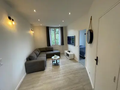a living room with a couch and a table at 2 pièces au calme in Cannes