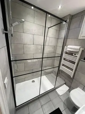 a bathroom with a glass shower with a toilet at 2 pièces au calme in Cannes