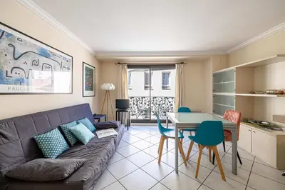 a living room with a couch and a table at LE CASANOVA avec balcon au cœur du centre-ville in Cannes