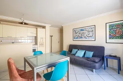 a living room with a glass table and a couch at LE CASANOVA avec balcon au cœur du centre-ville in Cannes