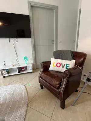 a brown leather chair with a love pillow on it at Nice & Cosy, 4 pers, 1 bedroom with balcony in Cannes
