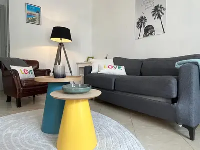 a living room with a couch and two tables at Nice & Cosy, 4 pers, 1 bedroom with balcony in Cannes