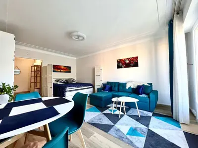 a living room with a blue couch and a table at B030 Grand studio renove spacieux et lumineux in Le Cannet