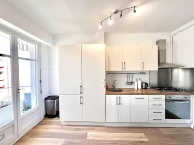 a kitchen with white cabinets and a large window at B030 Grand studio renove spacieux et lumineux in Le Cannet