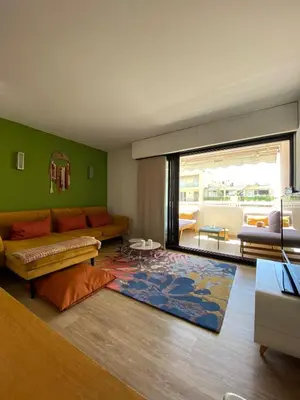 a living room with a couch and a rug at T3 pièces lumineux à à 1 min de la plage Quartier Palm Beach Cannes in Cannes