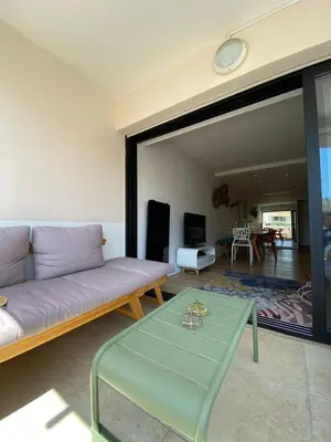 a living room with a couch and a glass table at T3 pièces lumineux à à 1 min de la plage Quartier Palm Beach Cannes in Cannes