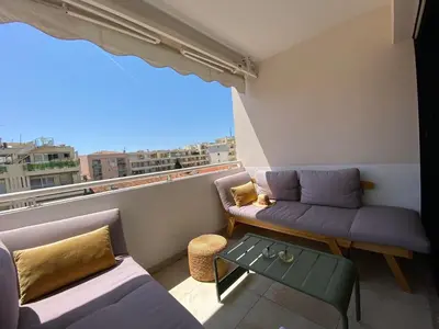 a small balcony with a couch and a table at T3 pièces lumineux à à 1 min de la plage Quartier Palm Beach Cannes in Cannes