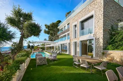 an exterior view of a house with chairs and a pool at Cannes villa 6 chambres - Elisabeth in Cannes