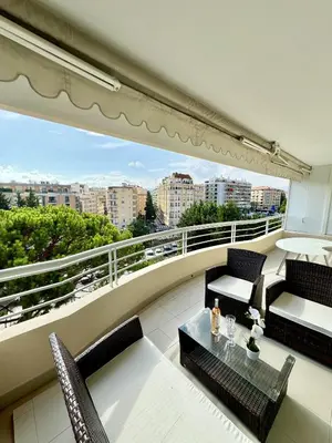 a balcony with chairs and a table and a view at 2 pieces proche mer GOLDEN in Cannes