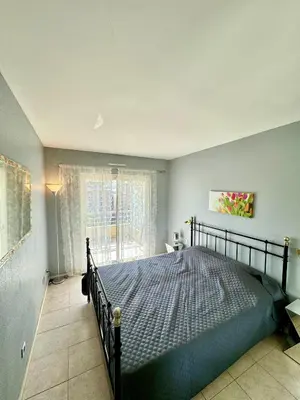 a bedroom with a bed and a large window at 2 pieces proche mer GOLDEN in Cannes