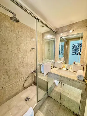 a bathroom with a glass shower and a sink at 2 pieces proche mer GOLDEN in Cannes
