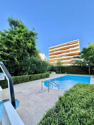 a swimming pool in front of a building at 2 pieces proche mer GOLDEN in Cannes