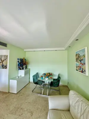a living room with a couch and a table and chairs at 2 pieces proche mer GOLDEN in Cannes
