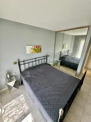 a bedroom with a bed and a large mirror at 2 pieces proche mer GOLDEN in Cannes