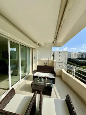 a balcony with a couch and a table and chairs at 2 pieces proche mer GOLDEN in Cannes