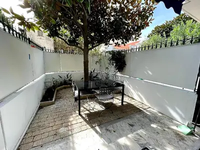 a table and a chair sitting next to a tree at Le Concorde By SCLS Locations in Cannes