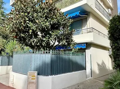 a building with a gate and a tree in front of it at Le Concorde By SCLS Locations in Cannes