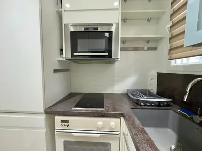 a small kitchen with a sink and a microwave at Le Concorde By SCLS Locations in Cannes