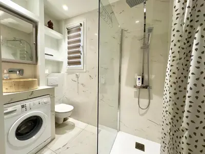 a bathroom with a shower and a washing machine at Le Concorde By SCLS Locations in Cannes