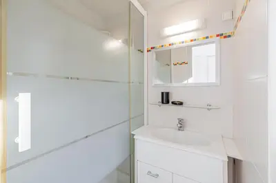 a white bathroom with a sink and a mirror at 16 FORV - Apartment for 4 people City center - 300m Palais in Cannes