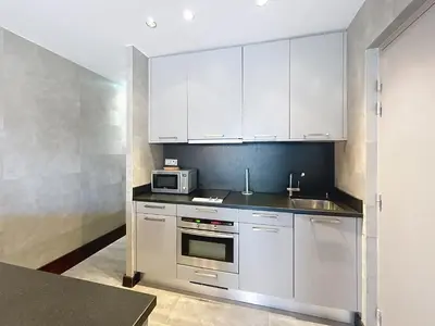 a kitchen with white cabinets and a sink and a microwave at Hoche in Cannes