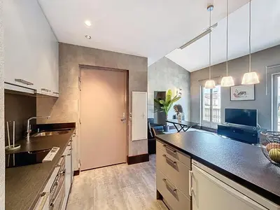 a large kitchen with a large counter top and a door at Hoche in Cannes