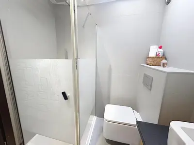 a white bathroom with a shower and a toilet at Hoche in Cannes