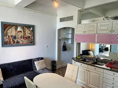 a living room with a couch and a kitchen at Studio coeur de Cannes 318L in Cannes