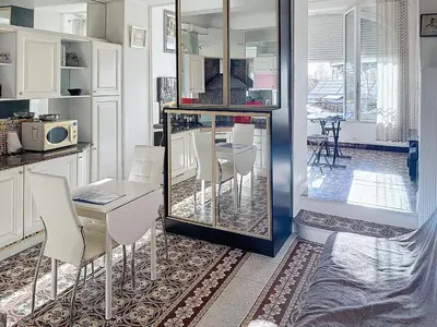 a dining room with a table and white chairs at Studio coeur de Cannes 318L in Cannes