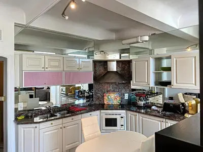 a kitchen with white cabinets and black counter tops at Studio coeur de Cannes 318L in Cannes