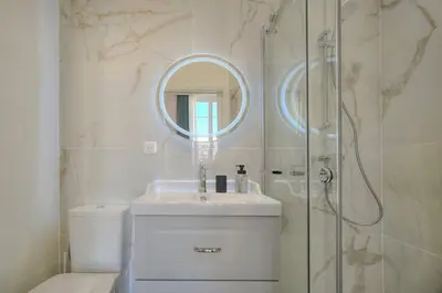 a bathroom with a sink and a shower with a mirror at Oasis du Sud 4 beds and 4 baths 10 min from Palais in Cannes