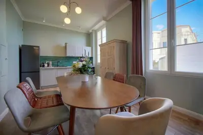 a dining room with a table and chairs and a kitchen at Oasis du Sud 4 beds and 4 baths 10 min from Palais in Cannes