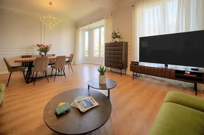 a living room with a large television and a table at SEA PEARL Luxury apartament by the Croisette and the beach in Cannes