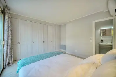 a white bedroom with a large bed in it at Serenity by the Sea 180 Degrees Sea View and Pool in Cannes