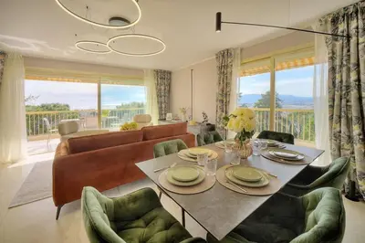 a living room with a table and chairs and a couch at Serenity by the Sea 180 Degrees Sea View and Pool in Cannes