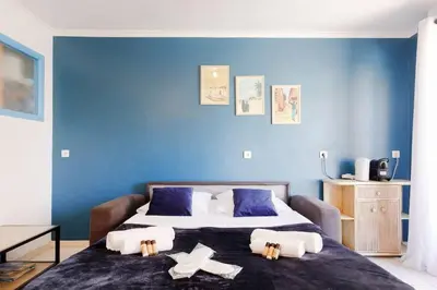 a bedroom with a large bed with blue walls at Charmant studio près de la mer in Cannes