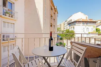 a bottle of wine sitting on a table on a balcony at Charmant studio près de la mer in Cannes