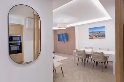 a living room with a dining room table and a mirror at Palais Carthage - 10 mn à pied du palais, Centre, Balcon in Cannes
