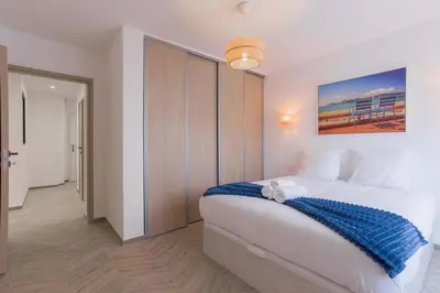 a bedroom with a bed with a blue blanket on it at Palais Carthage - 10 mn à pied du palais, Centre, Balcon in Cannes