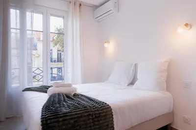 a bedroom with a white bed and a window at Palais Carthage - 10 mn à pied du palais, Centre, Balcon in Cannes