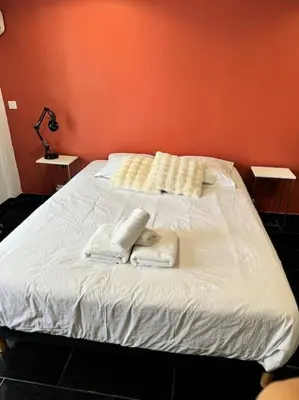 a white bed with two towels on top of it at Grand Studio Centre Cannes in Cannes