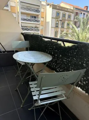 a balcony with a table and chairs on a balcony at Grand Studio Centre Cannes in Cannes