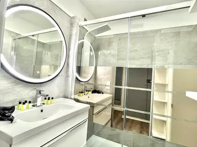 a bathroom with a sink and a glass shower at Château de la mer, by Welcome to Cannes in Cannes