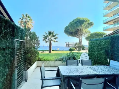 a table and chairs on a patio with a view of the ocean at Château de la mer, by Welcome to Cannes in Cannes