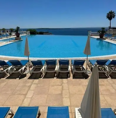 a swimming pool with lounge chairs and umbrellas at Stunning condo with SEA VIEW Balcony & SWIMMING POOL in Cannes