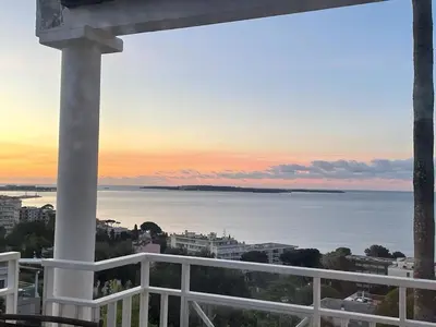 a view of the ocean at sunset from a balcony at Stunning condo with SEA VIEW Balcony & SWIMMING POOL in Cannes